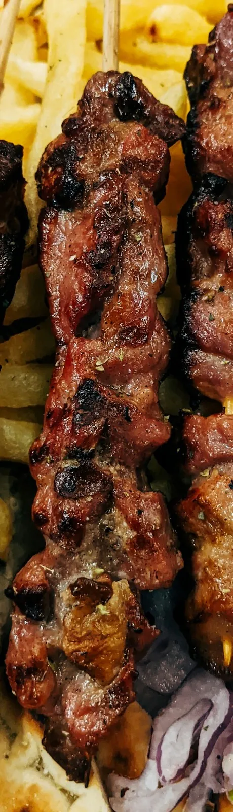 Kebap, sumaklı soğan ve közlenmiş domates